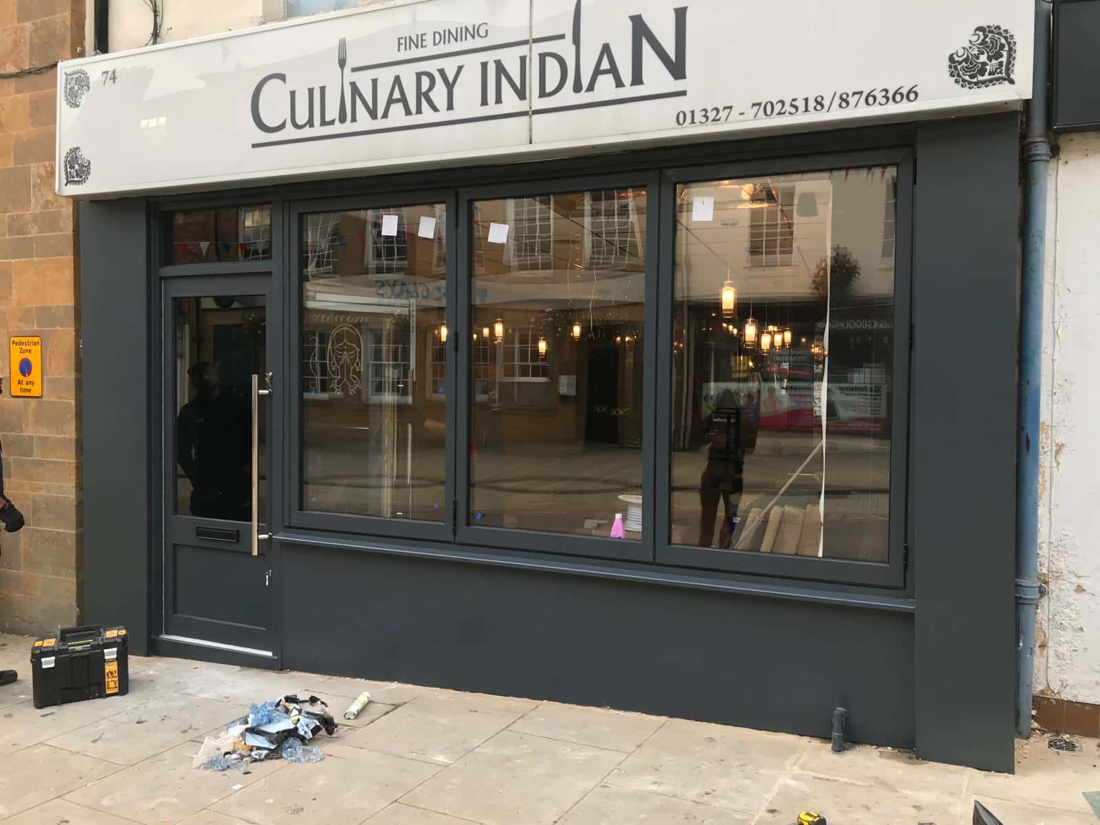 A dark grey aluminium restaurant front we fitted, with a glazed door, fixed display glazing and a painted fascia